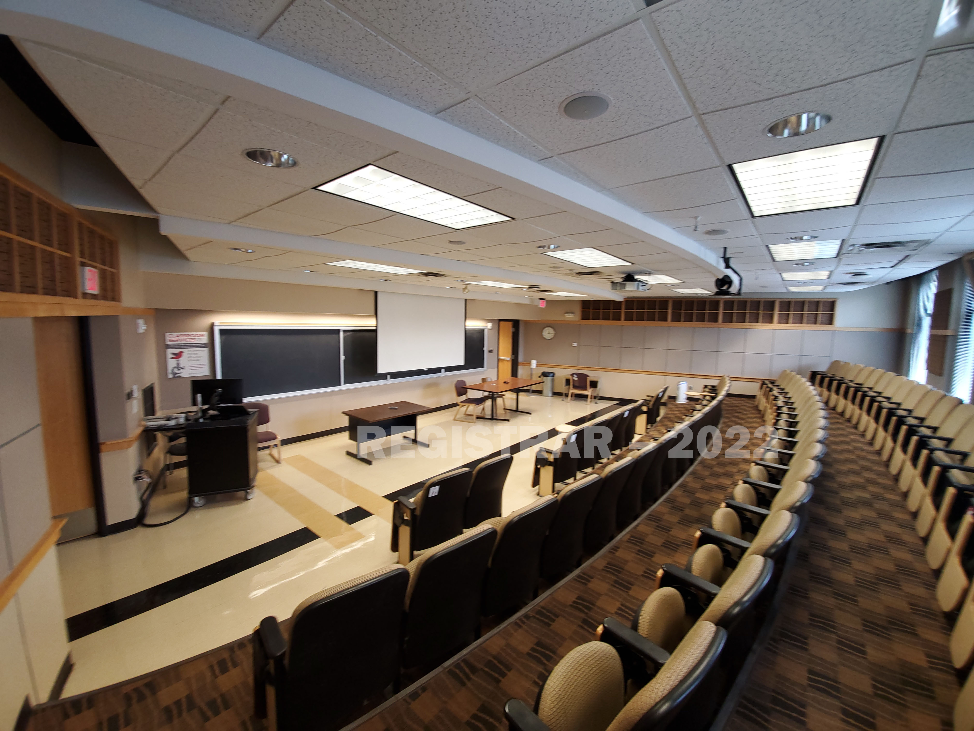 Cockins Hall room 240 ultra wide angle view from the back of the room with projector screen down