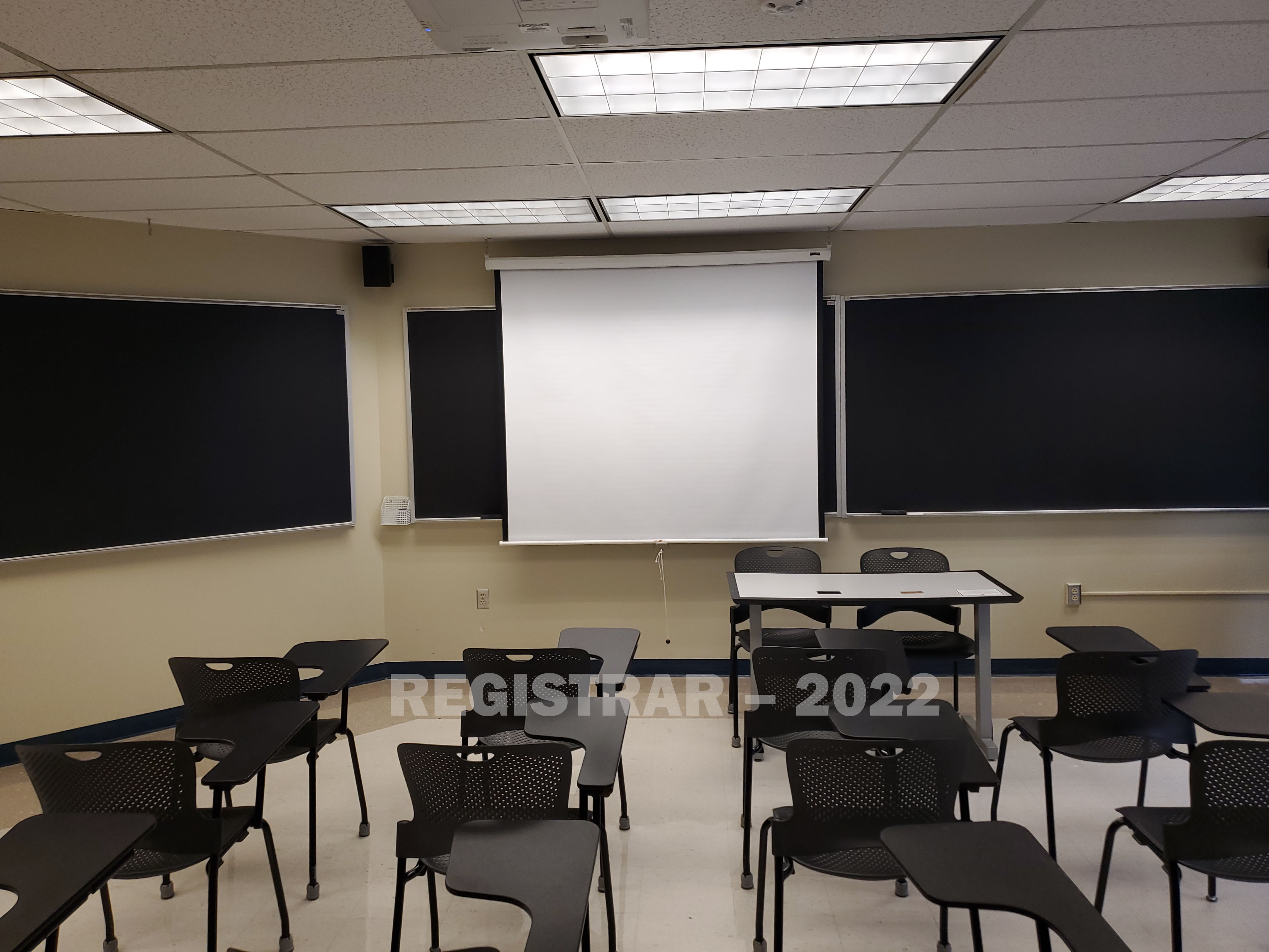 Enarson Classroom Building room 230 view from the back of the room with projector screen down