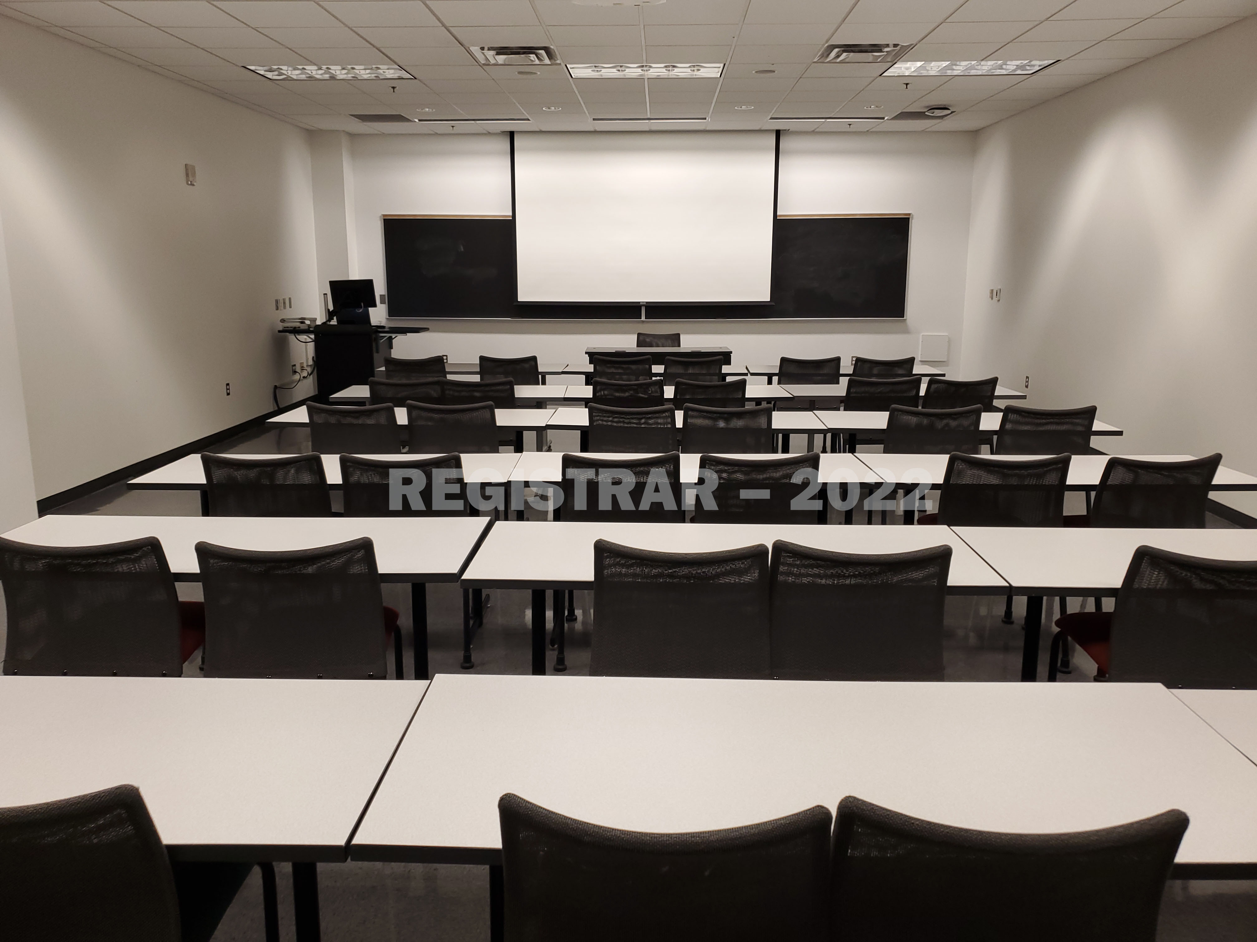 Scott Lab room North 56 view from the back of the room with projector screen down
