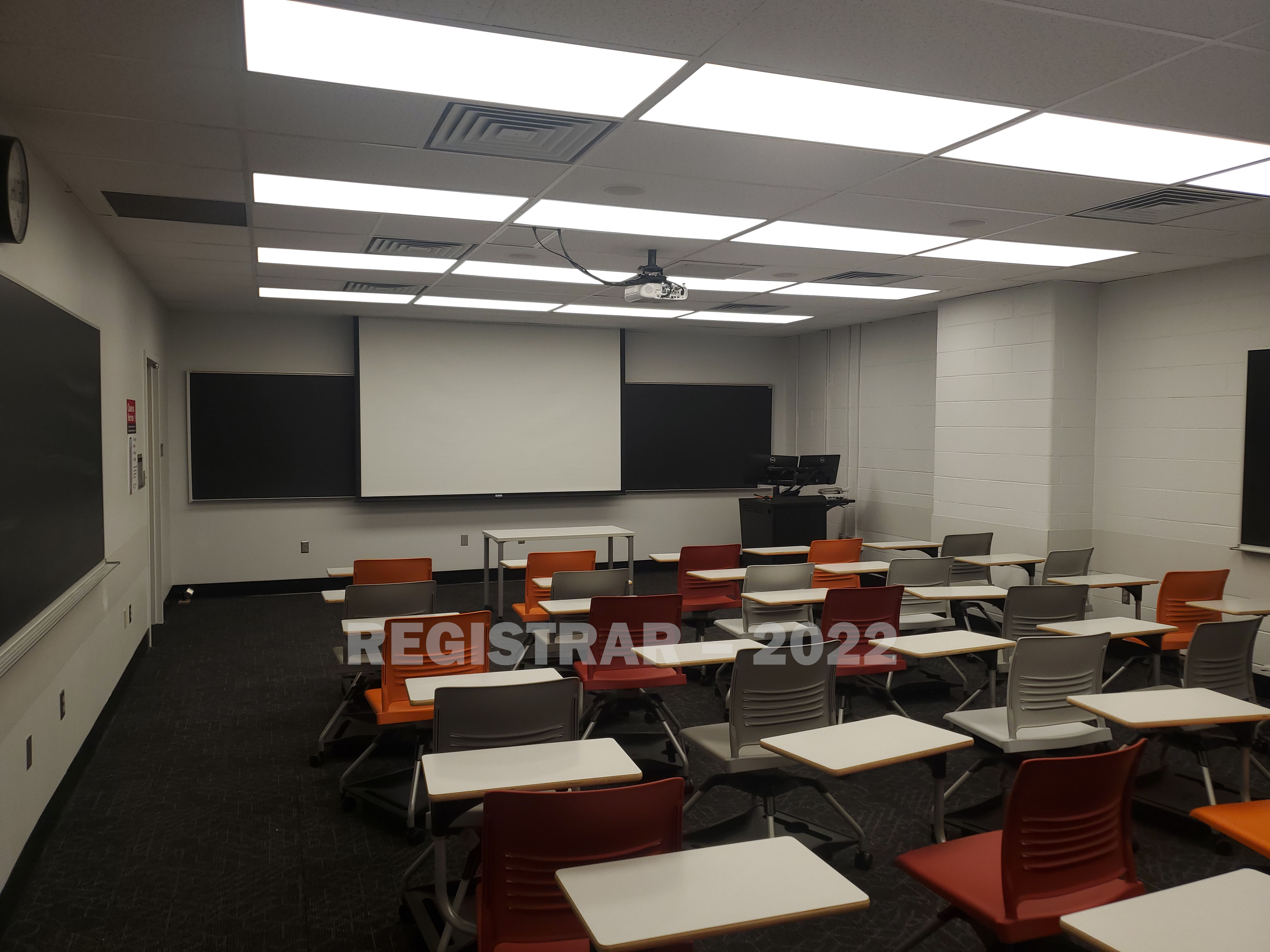 Journalism Building room 353 view from the back of the room with projector screen down