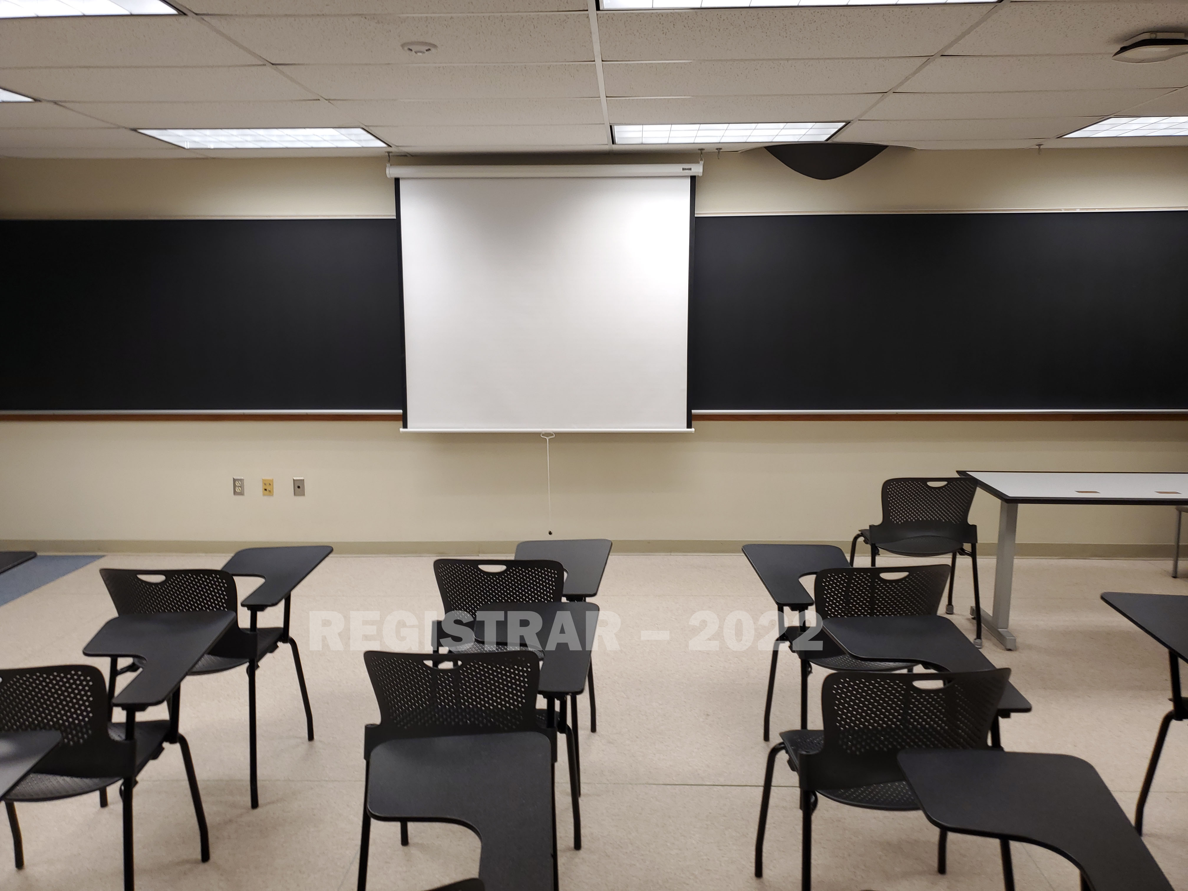 Enarson Classroom Building room 322 view from the back of the room with projector screen down
