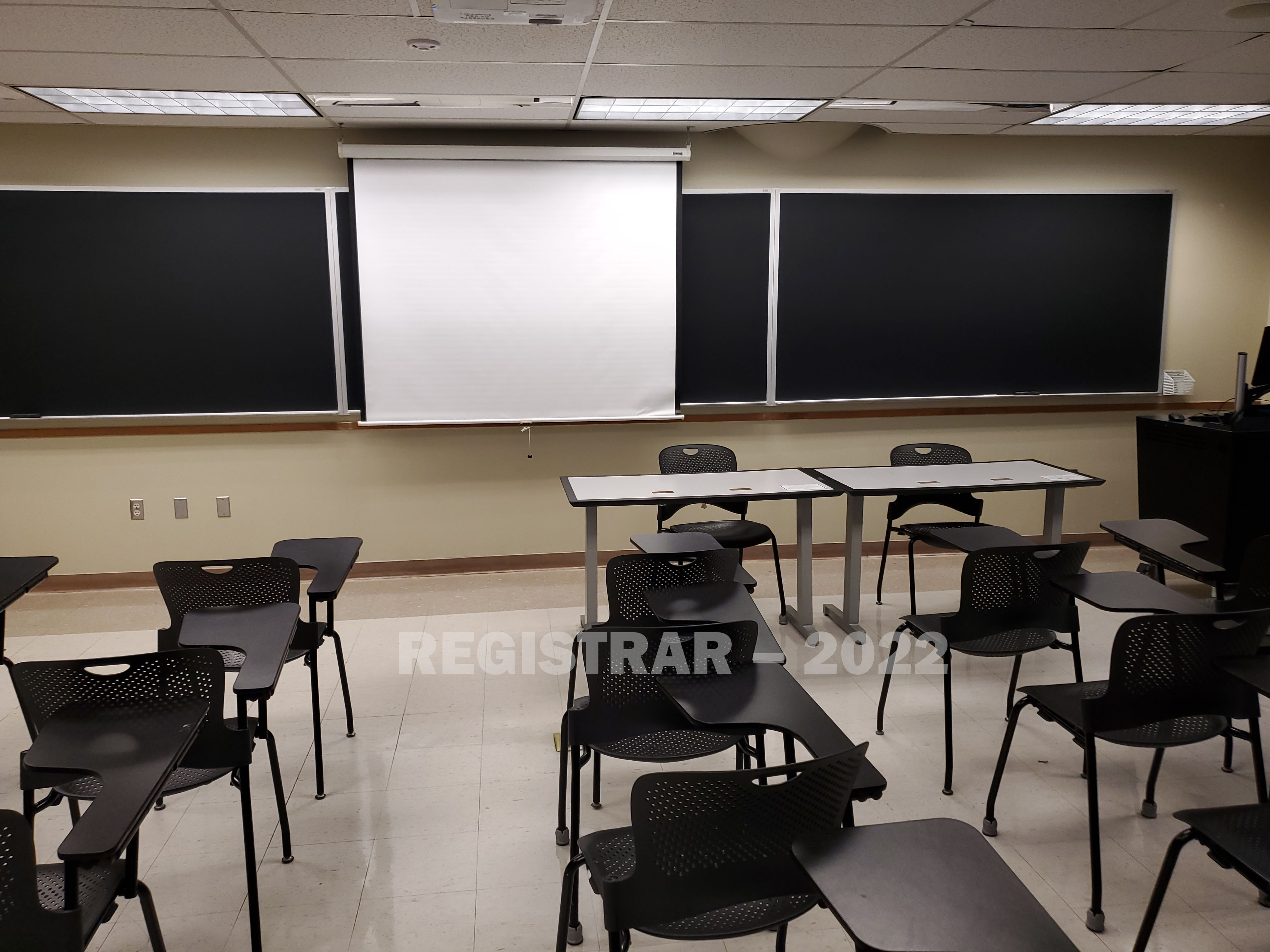 Enarson Classroom Building room 222 view from the back of the room with projector screen down